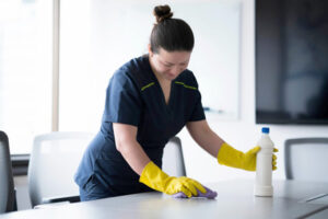 Joven con uniforme realizando limpieza después de una mudanza en Medellín y alrededores.