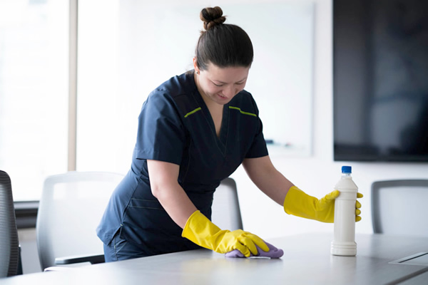 Joven con uniforme realizando limpieza después de una mudanza en Medellín y alrededores.